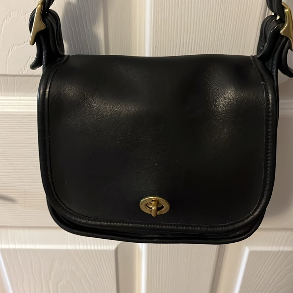 Coach black leather bag. Inside zipper pocket, back slip pocket. 8”Wx71/2Hx41/2T